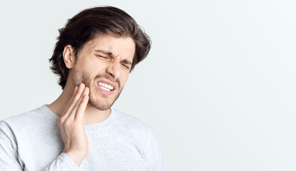 Dental problems concept. Man suffering from bad toothache, empty space