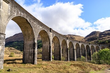 Fototapeta premium Glenfinnan Viaduct: A Majestic Railway Bridge Arching Over the Scottish Highlands