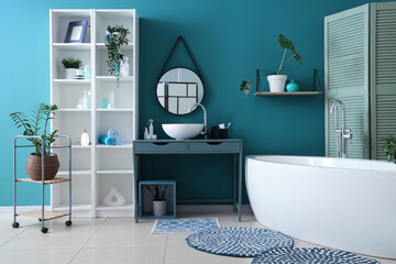 Interior of bathroom with bathtub, sink and shelf unit