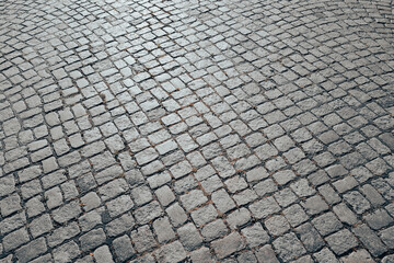 Pavement road. Background of bricks road. Stone cladding pavement. Brick surface background. Rough brick road. Cobblestone pavement background. Textured background. Sidewalk. Old cobblestone road.