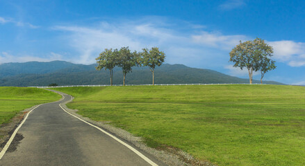 Asphalt road in countryside with blue sky on sunny day