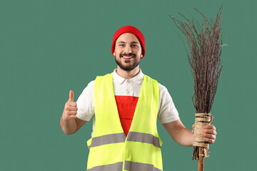 Male scavenger with broom showing thumb-up on green background