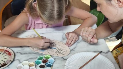  A young mother and her daughter enjoy a creative art session at home 