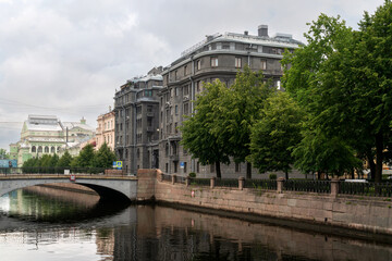 View of the Kryukov Canal embankment and an apartment building made of dark gray granite on an summer day, St. Petersburg, Russia