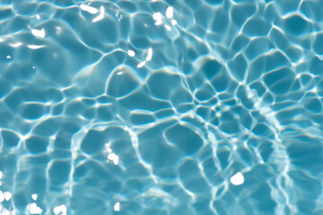 Blue water with ripples on the surface. Defocus blurred transparent blue colored clear calm water surface texture with splashes and bubbles. Water waves with shining pattern texture background.