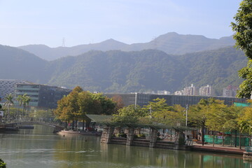 Fototapeta premium A city with a river running through it and mountains in the background