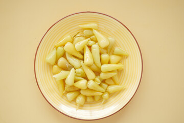 Top View of Pickled Vegetables in a Yellow Ceramic Bowl on Table