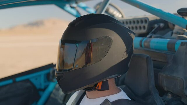 Man buckling helmet in offroad vehicle