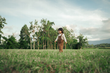 happy toddle baby girl walking on grass field