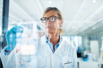 Woman, scientist and formula on glass wall at laboratory for planning, strategy and ideas on...