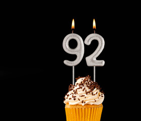 Birthday cupcake on black background - Number 92 shaped candles.