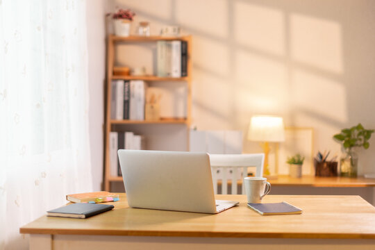 Computer laptop on a wooden desk in a room home office
