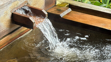 檜の露天風呂の湯口から流れる癒しの源泉湯	