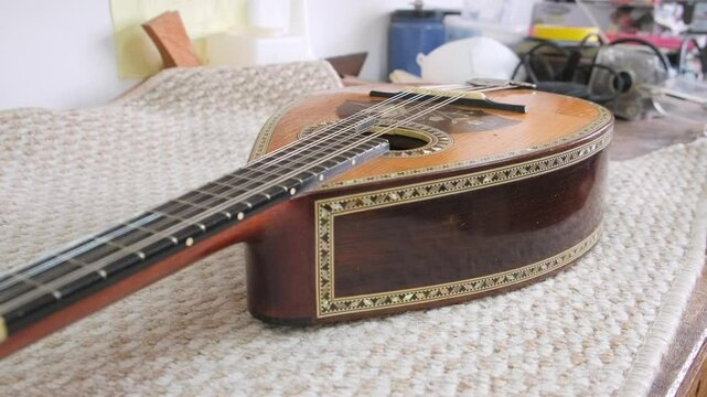 Luthier is presenting a mandolin he is crafting in his workshop