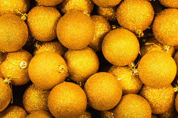Background of Christmas, New Year golden balls with glitter, top view. Textured background