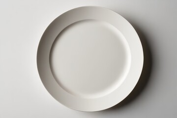 there is a white plate with a white rim on a white table