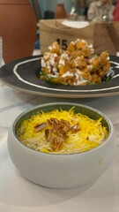 Fried calamari with turmeric yellow-coloured rice with toasted almond on top.