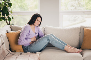 Obraz premium Full length photo of lovely young teen girl suffer stomach pain dressed violet garment spacious house bright indoors room