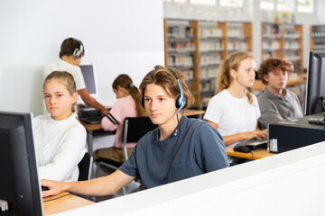 Schoolboy and schoolgirl working with computers in classroom