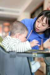 Obraz premium A 6-month-old boy has his mouth wiped by his mother from a Chinese family on a cold winter day in an apartment building in Pudong New District, Shanghai, China.