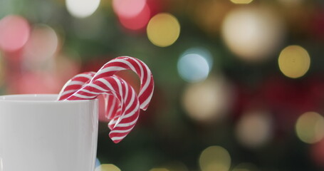 Candy canes rest in a mug against a festive backdrop, with copy space © vectorfusionart