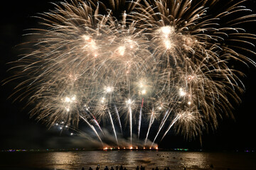 People with colorful fireworks celebration and the midnight sky background at the seaside.