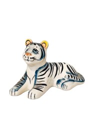 A white and black tiger figurine is sitting on a white background