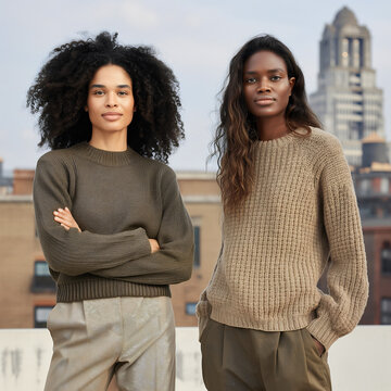 Two diverse models stand confidently wearing eco-friendly clothing made from natural fabrics against a minimalist urban background, highlighting a modern and clean aesthetic