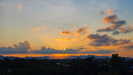 Fototapeta premium A breathtaking sunset paints the sky with hues of orange, pink, and purple, casting a warm glow over the distant landscape and creating a sense of tranquility. 