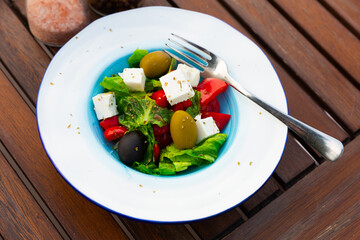 Delicious salad with olives, tomatoes, cucumber and feta cheese - greek vegetable salad. Traditional mediterranean cuisine