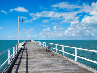 Naklejka premium A beautiful pier featuring a white railing gracefully leading into the ocean Hervey Bay Fraser Australia