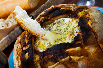 Traditional French dish of melted camembert cheese (fondue) in fresh baked bread with dried herbs...