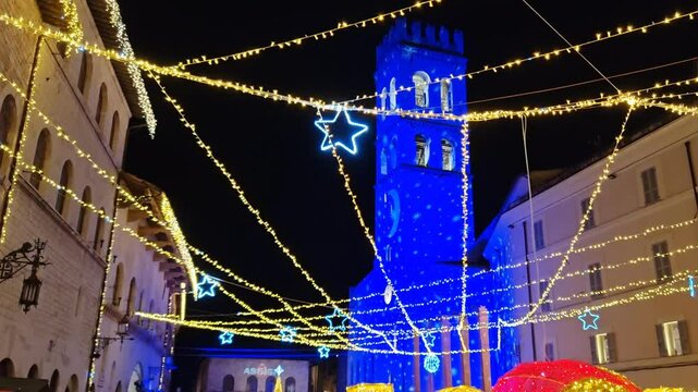 Town square of Assisi with the Torre del Popolo at night. The city of San Francesco with the lights of christmas, Umbria region