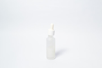 White dropper glass bottle with white liquid inside on isolated white background