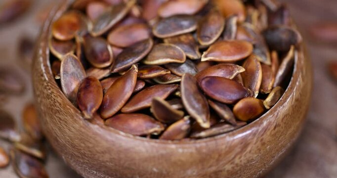 heavily fried pumpkin seeds in close-up, overcooked or burnt pumpkin seeds on the table