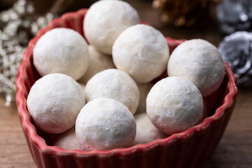 赤い器に盛り付けたスノーボールクッキーとクリスマス装飾のテーブル