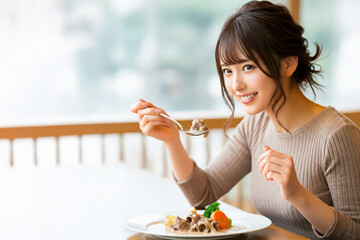 クリームシチューを食べる若い女性