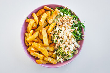plate with half chips and half salad topped with tofu and almonds, healthy food vs junk food concept