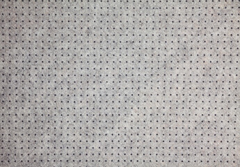 Background of light grey felt material with dark dots