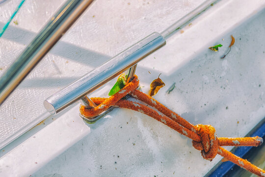 Knot on the boat. Attaching a rope from the boat to the wooden pier. Securing a motorboat.