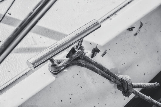 Knot on the boat. Attaching a rope from the boat to the wooden pier. Securing a motorboat.