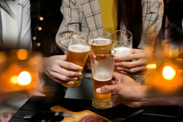 food and drink male friends are happy drinking beer and clinking glasses at a bar or pub.