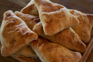 Delicious Asian food, Traditional eastern cuisine Tajikistan, Uzbekistan, Kyrgyzstan, Kazakhstan. Triangular puff pastry samosas. Fresh baked goods: samsa with meat or potato close up, side view. 