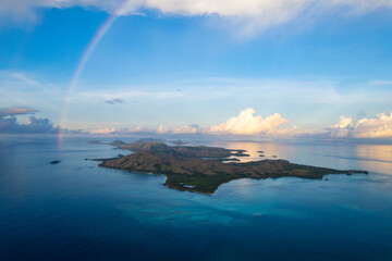 Aerial view of rainbow above tropical remote paradise Iisland at sunset