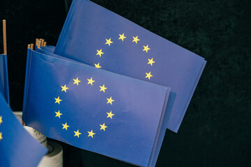 Das Foto zeigt mehrere kleine Europaflaggen, die ordentlich arrangiert sind. Die Flaggen haben...