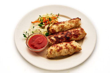 A plate of meat and vegetables with a red sauce