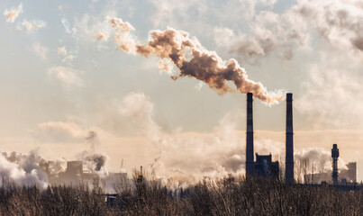 A large cloud of smoke is rising from a factory