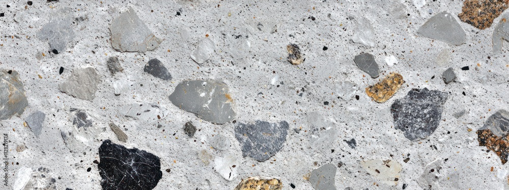 Aufkleber A close-up view of textured concrete with various aggregate stones.