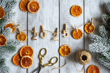 New Year 2025 garland of dry oranges on a light table.