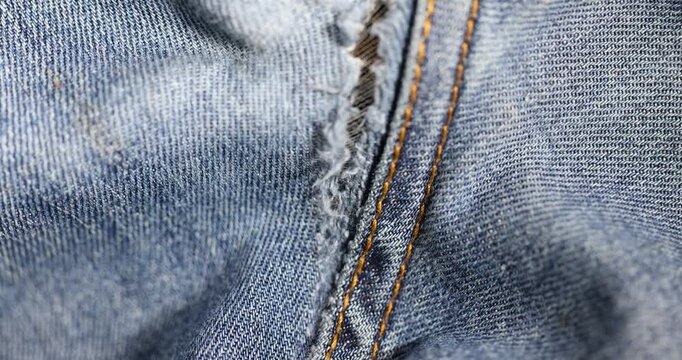 details of old torn jeans from frequent wear, damaged jeans with a hole in the fabric suitable for repair and stitching